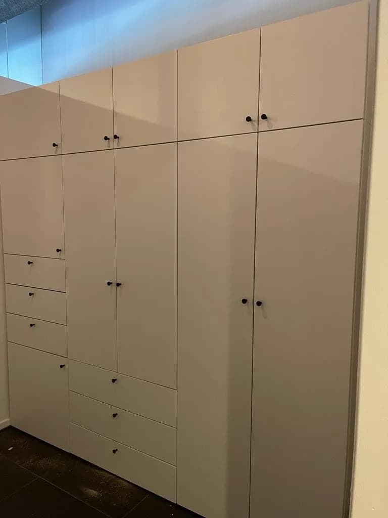 Detailopname van een afgewerkte scharnier op een zojuist opgeleverde kast